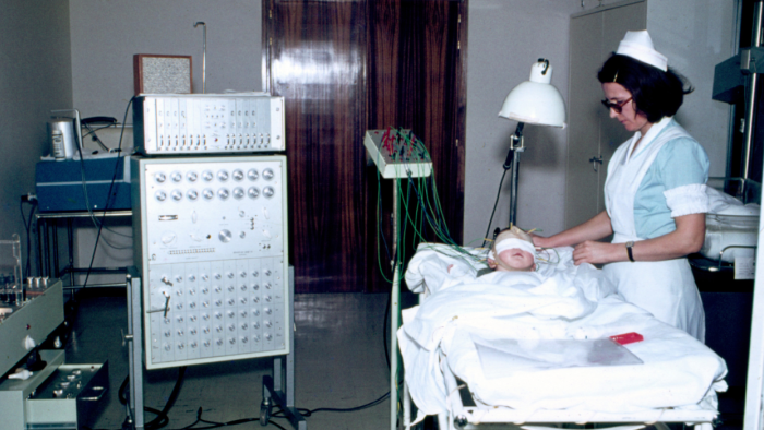 Professional performing an electroencephalogram to a paediatric patient