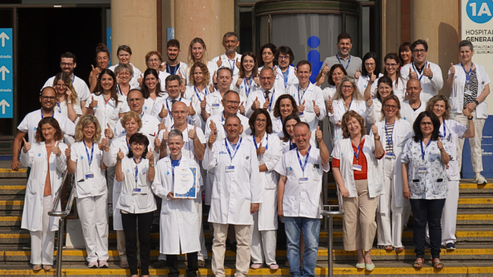 Fotografia de tot l'equip implicat en la cura dels pacients amb càncer davant de la porta de l'Hospital General