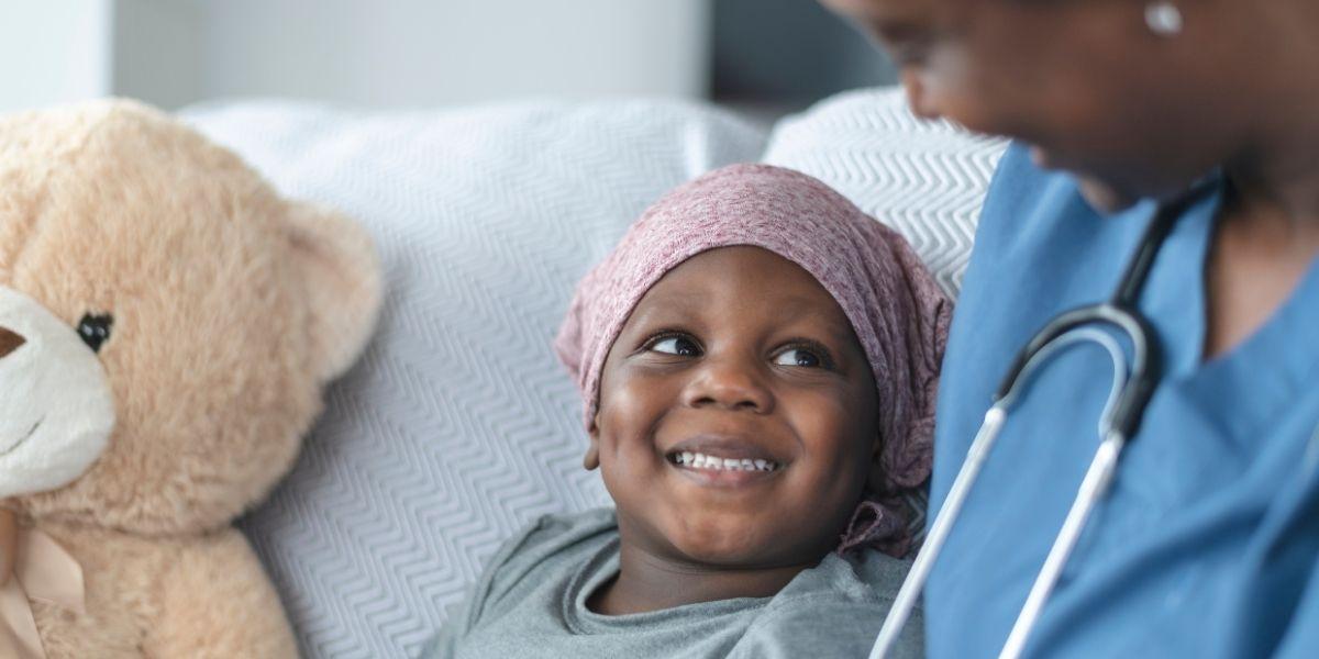 Nen amb càncer acompanyat d'una infermera