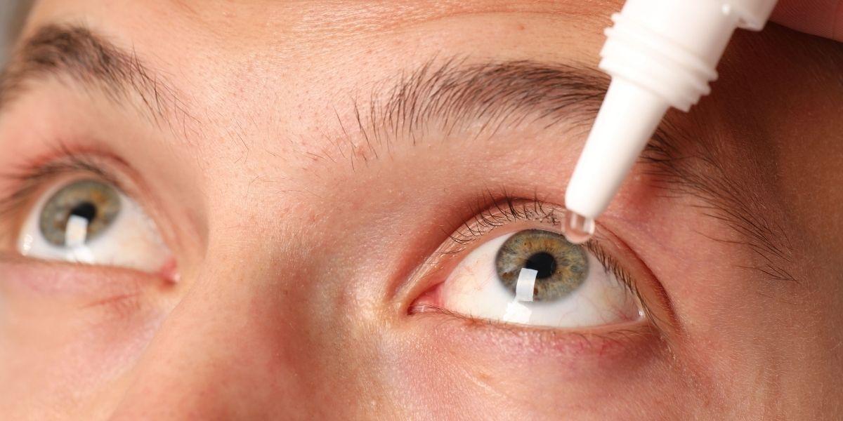 Persona posant-se gotes als ulls a causa de la conjuntivits