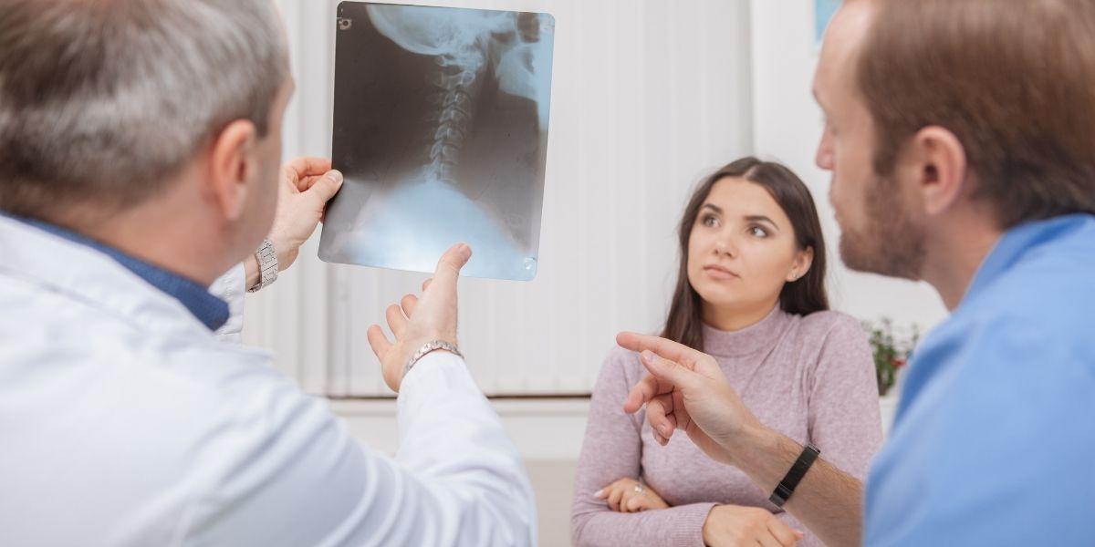 Metge mirant una radiografia amb dos pacients